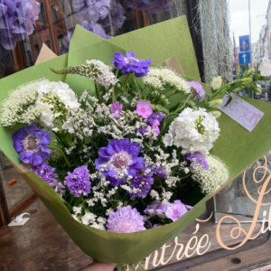 Bouquet Beaucoup Versus Fleurs, fleurs violettes et blanches, devant la boutique rue Haute